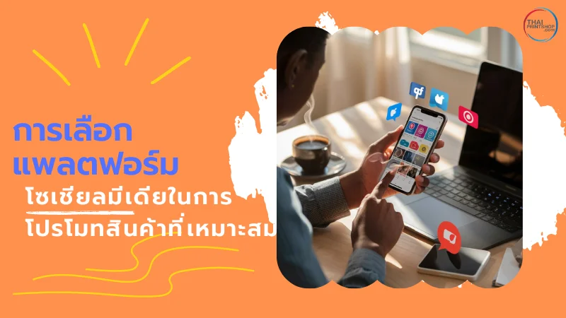 5 วิธีการใช้ Socia Media ในการโปรโมทสินค้าอย่างมีประสิทธิภาพ - Thaiprintshop ชายคนหนึ่งกำลังเลือกแอปพลิเคชันโซเชียลมีเดียบนสมาร์ทโฟนที่อยู่บนโต๊ะ พร้อมข้อความ 'การเลือกแพลตฟอร์มโซเชียลมีเดียในการโปรโมทสินค้าที่เหมาะสม'