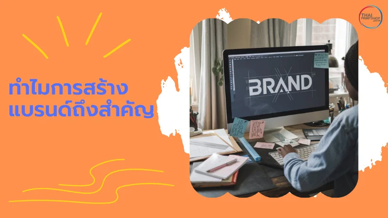 Rebranding ด้วยแพคเกจสินค้าและสติ๊กเกอร์แบรนด์ มีเทคนิคอะไรบ้าง? - Thaiprintshop ภาพของบุคคลที่กำลังทำงานออกแบบโลโก้แบรนด์บนหน้าจอคอมพิวเตอร์ โต๊ะทำงานที่เต็มไปด้วยกระดาษและโพสต์อิท พร้อมข้อความ 'ทำไมการสร้างแบรนด์ถึงสำคัญ'
