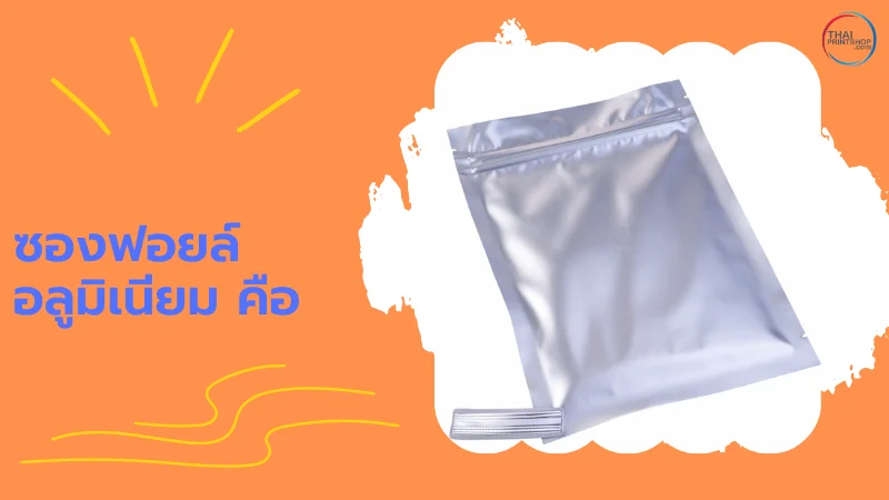 ความแตกต่างระหว่าง ซองฟอยล์เมทัลไลท์ Vs ฟอยล์อลูมิเนียม เลือกแบบไหนดี? - Thaiprintshop ซองฟอยล์อลูมิเนียมสีเงินวางอยู่บนพื้นหลังสีส้ม